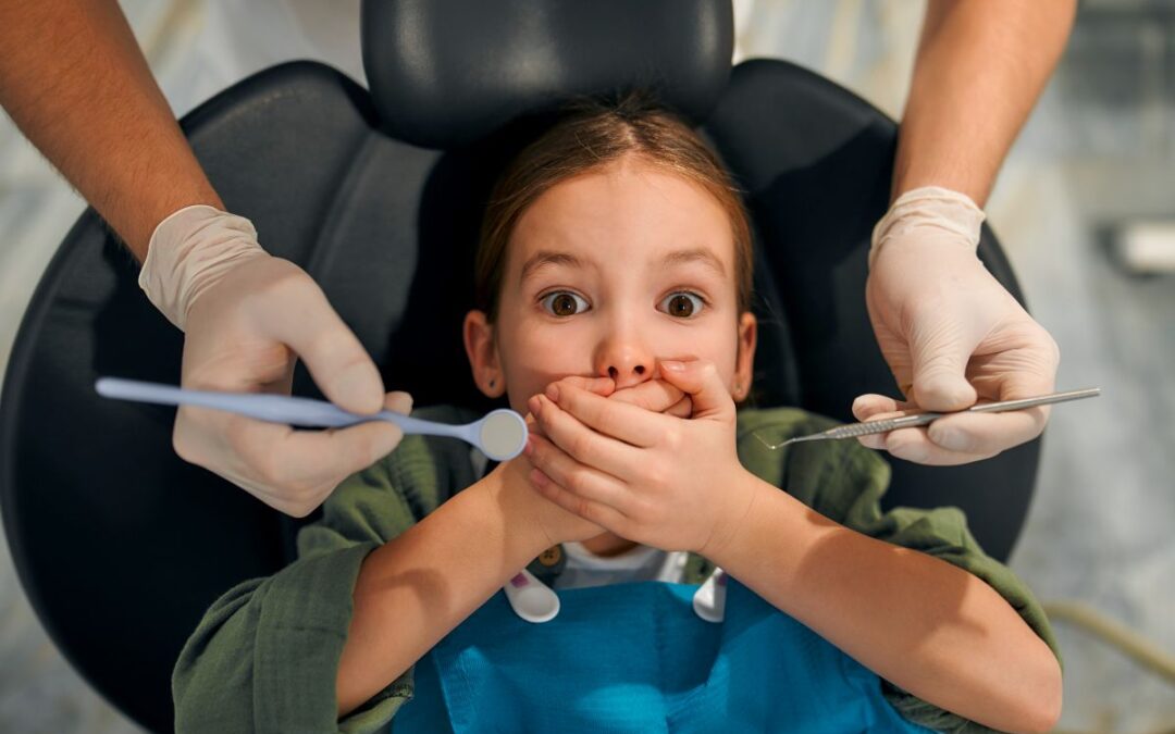 Pediatric dentist comforting a child with dental anxiety