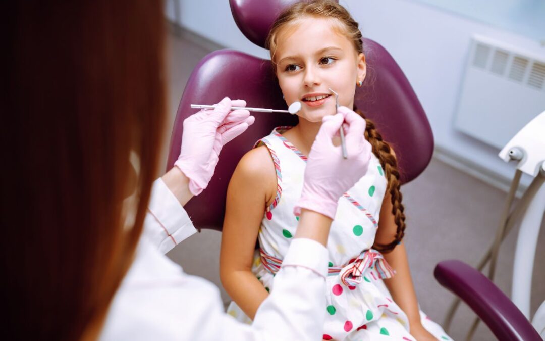 Pediatric dentist applying preventive dental sealants on child’s teeth